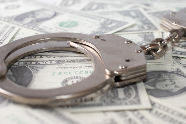 Closeup view of metal handcuffs and dollars