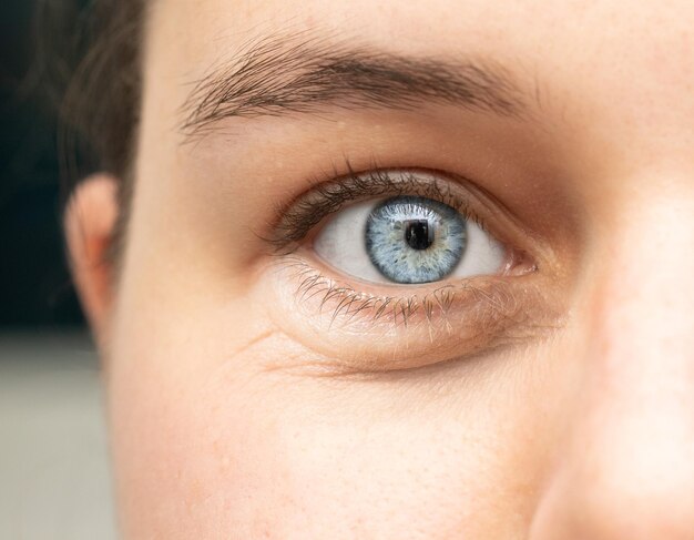 A closeup view on the open eye of a beautiful young Caucasian wo