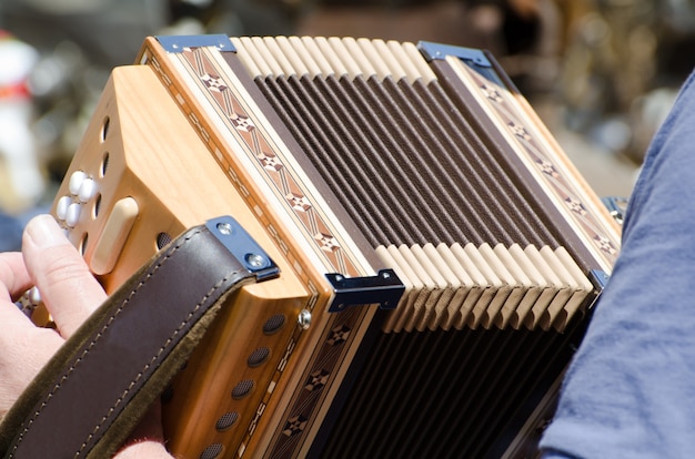 Closeup view of a person holding and playing the accordion