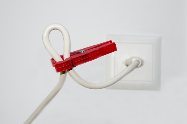 Closeup of a white cable and a red clothespin