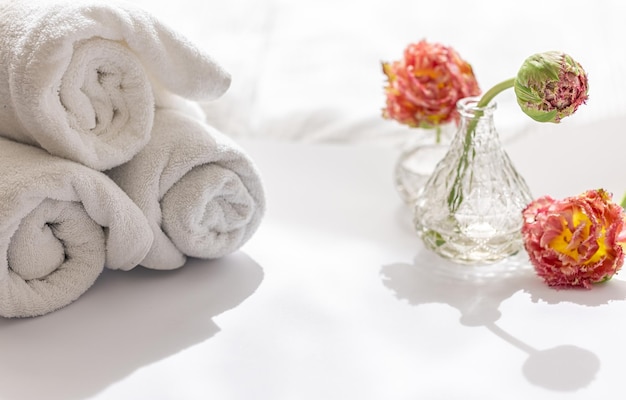 Closeup white terry bath towels and flowers