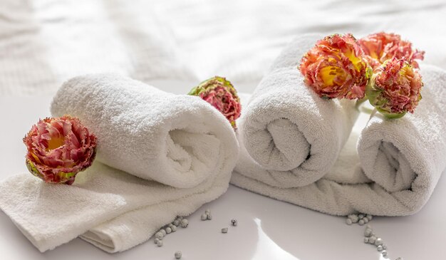 Closeup white terry bath towels and flowers