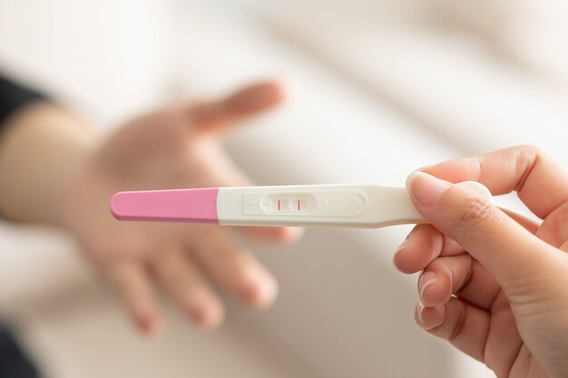 Closeup of a wife giving a positive pregnancy test to the husband