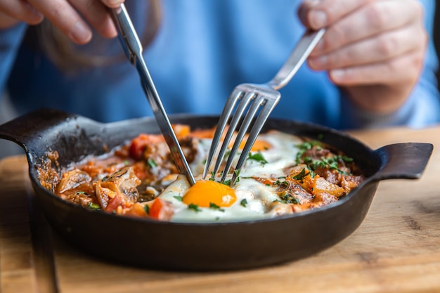 Closeup a woman in a cafe dines on traditional shakshuka