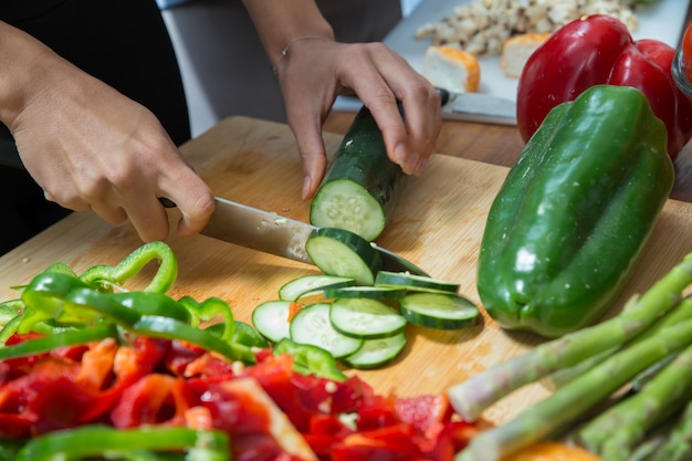 Free photo closeup of woman cutting fresh cucumber