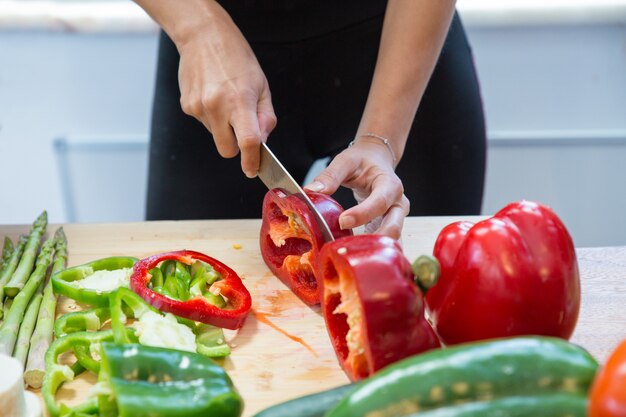 Closeup of woman cutting fresh sweet pepper