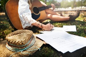 Primo piano del musicista della donna che si siede comporre musica nel parco