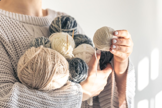 Closeup woman hands holding several colored balls of thread