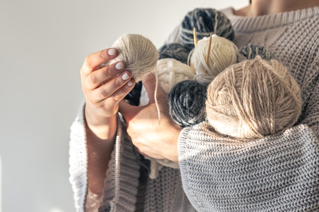 Free photo closeup woman hands holding several colored balls of thread