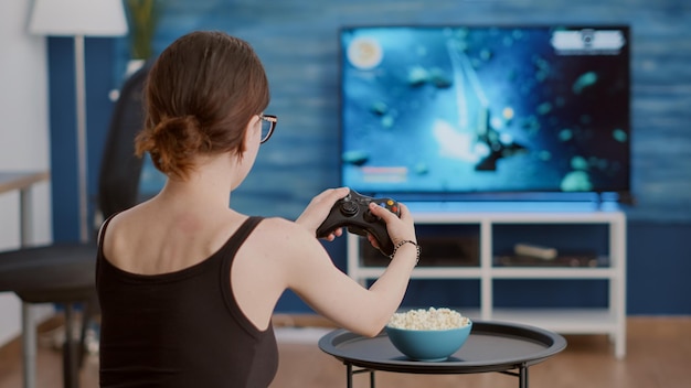 Free photo closeup of woman holding controller celebrating victory in online first person shooter game