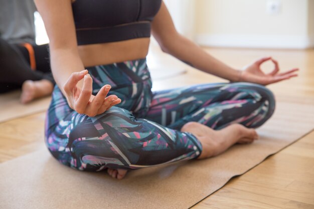 Closeup of woman holding hands in mudra gesture at yoga class