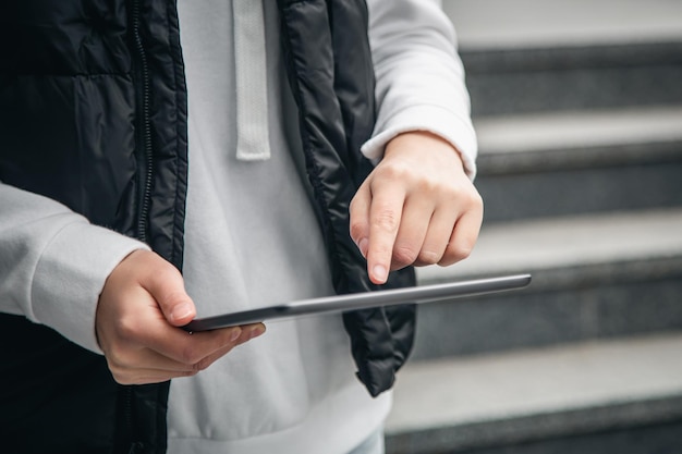 Closeup a woman is using a tablet outside