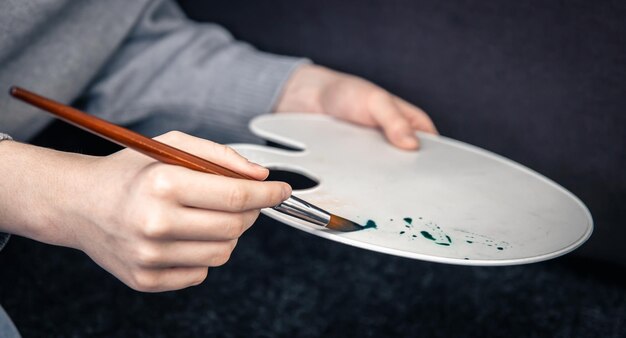 Closeup a woman paints with a palette