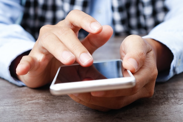 Primo piano della donna che utilizza smartphone al tavolo