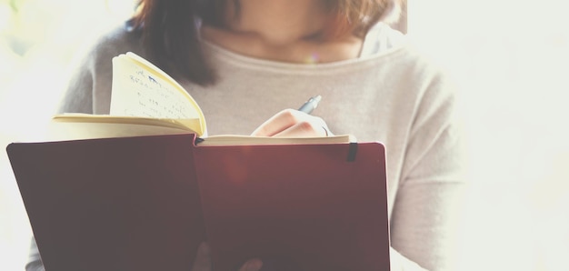 Closeup of woman writing notebook