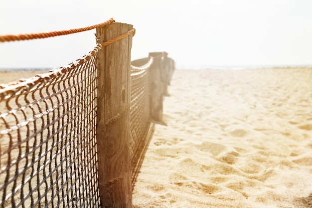 Closeup of Wooden Old Fence on Beach. Day Light. Sunny Light. Horizontal. Copy Space.