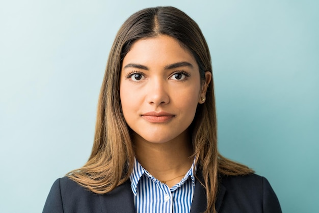 Free photo closeup of young female professional making eye contact against colored background