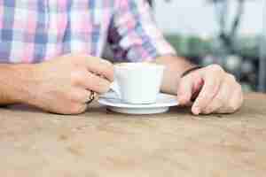 Foto gratuita primo piano del giovane che beve caffè all'aperto