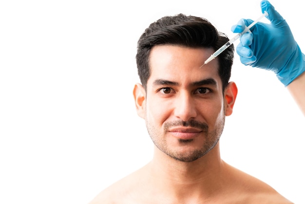 Free photo closeup of young man receiving botox injection on his face on white background