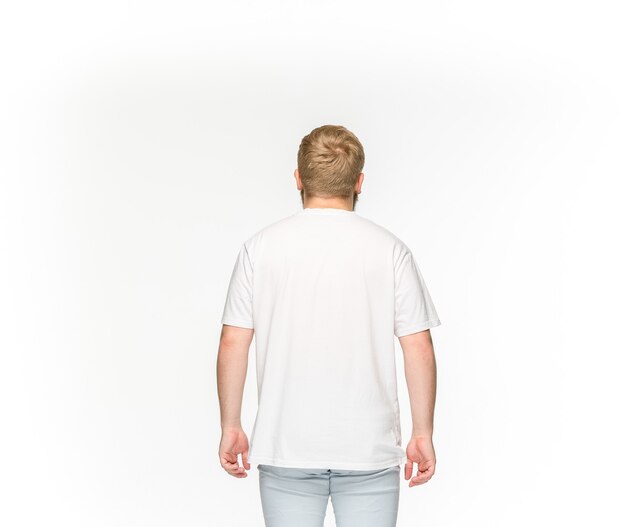 Closeup of young man's body in empty white t-shirt isolated on white.