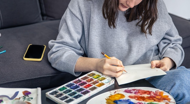 Primo piano una giovane donna disegna uno schizzo con una matita