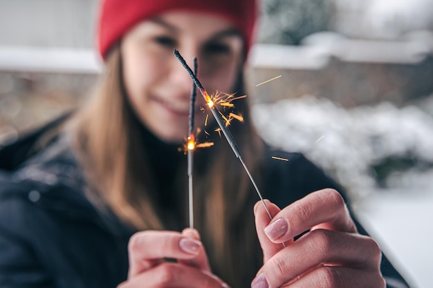 Closeup young woman holding sparklers in her hands