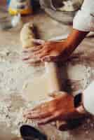 Free photo closeup of young woman rolling dough with rolling pin