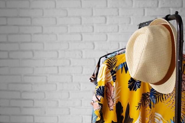 Clothing rack with floral hawaiian shirts on hangers and hat