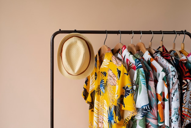 Clothing rack with floral hawaiian shirts on hangers and hat