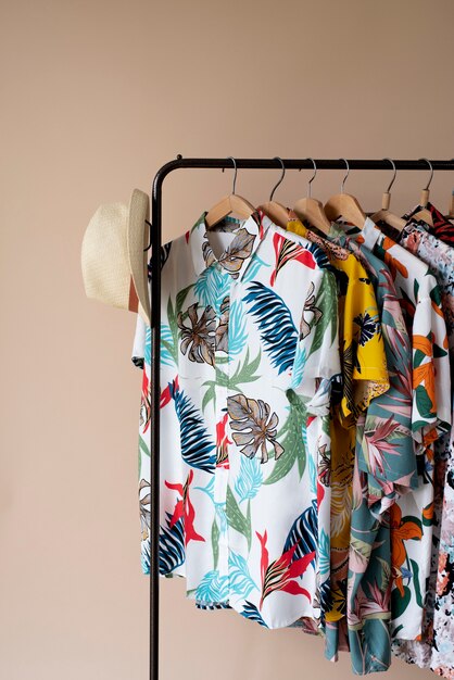 Clothing rack with floral hawaiian shirts on hangers and hat