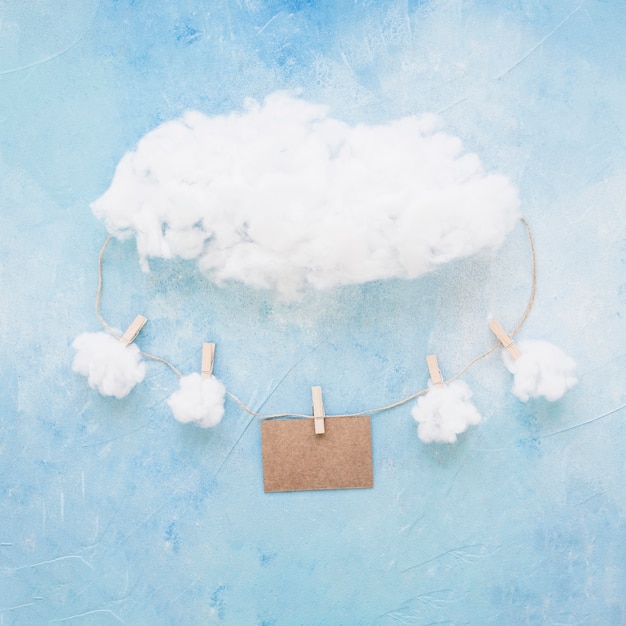 Clouds and card hanging on string with clothespins on blue background