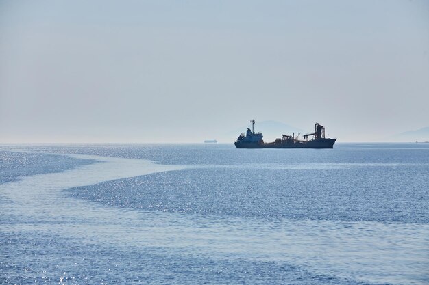 曇りの地平線と海の上の霧は地平線上の自然な背景の貨物船を波打ちます