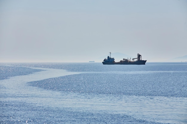 曇りの地平線と海の上の霧は地平線上の自然な背景の貨物船を波打ちます