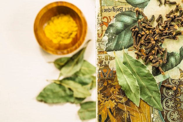 Cloves and bay leaves near blurred turmeric