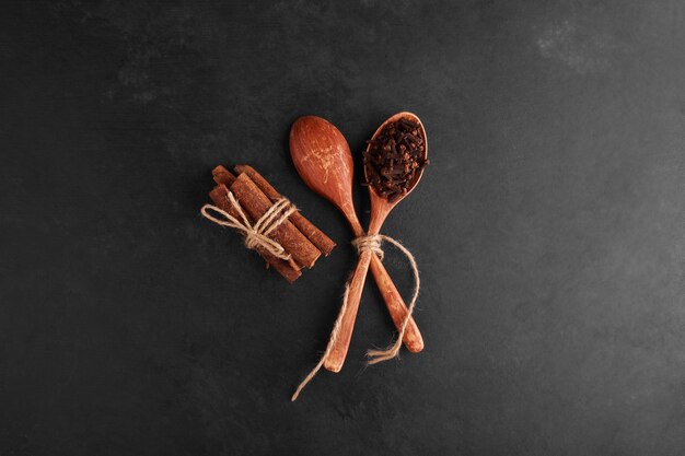 Cloves and cinnamons in a wooden spoon. 