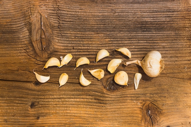 Cloves and garlic bulb on wooden textured backdrop