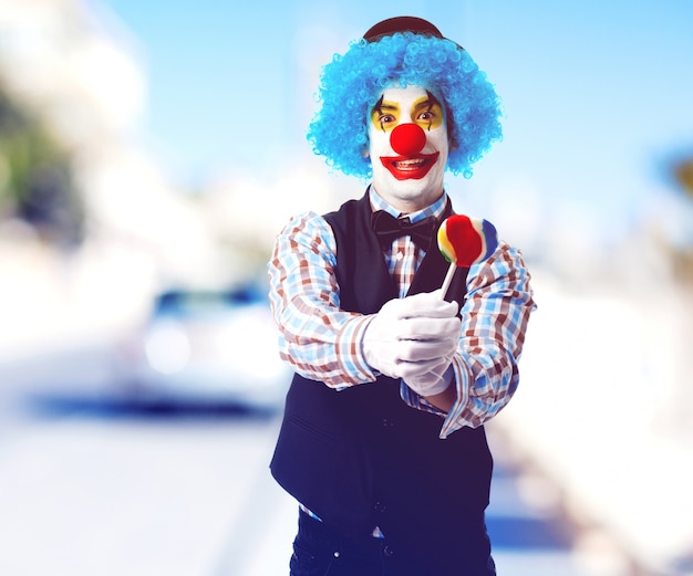 Free photo clown offering a lollipop