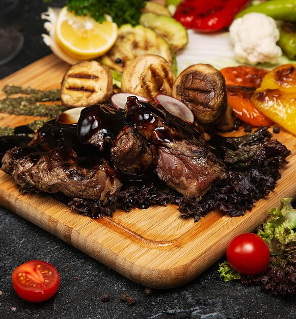 Club Beef steak with pepper sauce and Grilled vegetables on cutting board