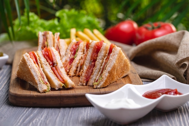 Club sandwich ham chicken tomato lettuce ketchup mayonnaise side view