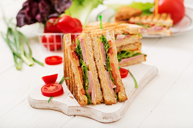 Club sandwich - panini with ham, cheese, tomato and herbs. Top view