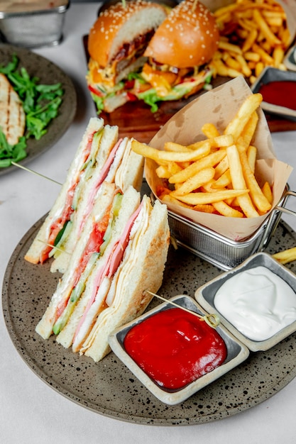 Club sandwich served with french fries ketchup and mayonnaise