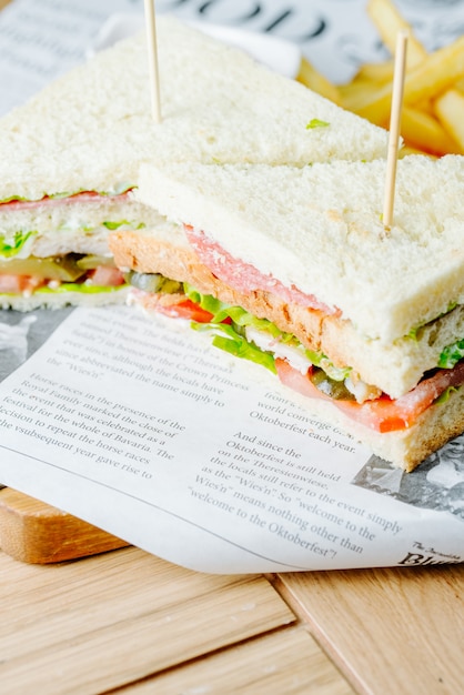 Foto gratuita club sandwich servito con patatine fritte