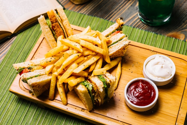 Club sandwich toast bread chicken tomato cucumber french fries mayonnaise ketchup side view