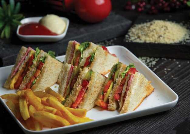 Club sandwich in white tray with roasted potatoes.