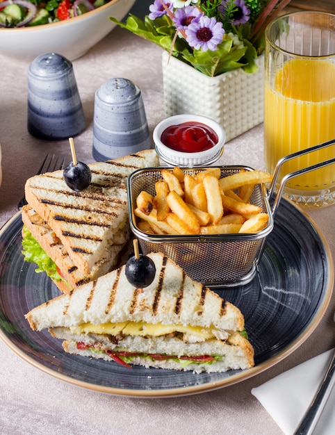 Club sandwich with chicken served with french fries