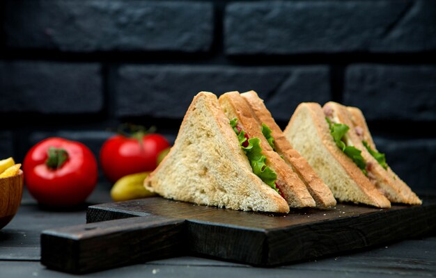 Club sandwich with crispy bread on a wooden board