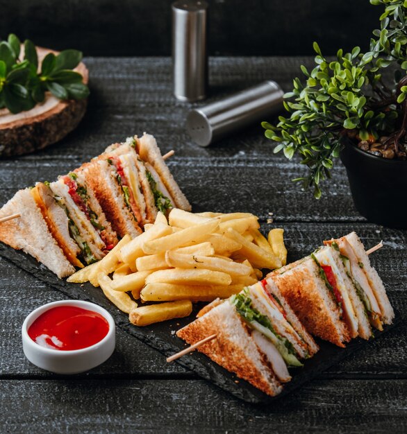 Club sandwich with french fries on the table