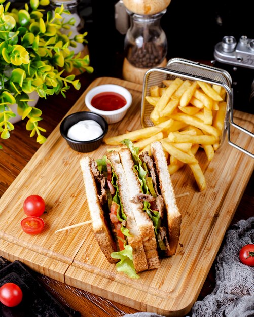 Club sandwich with french fries on the table