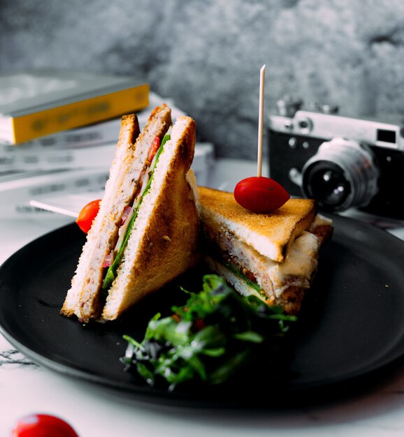 Club sandwich with tomato on top and herbs
