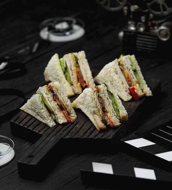 Free photo club sandwiches on a black wooden board